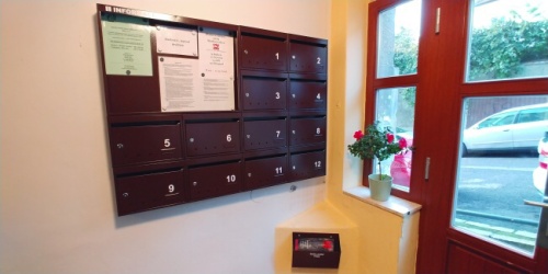 Poštové schránky typ Mini s informačnou nástenkou zakomponovanou medzi schránkami.